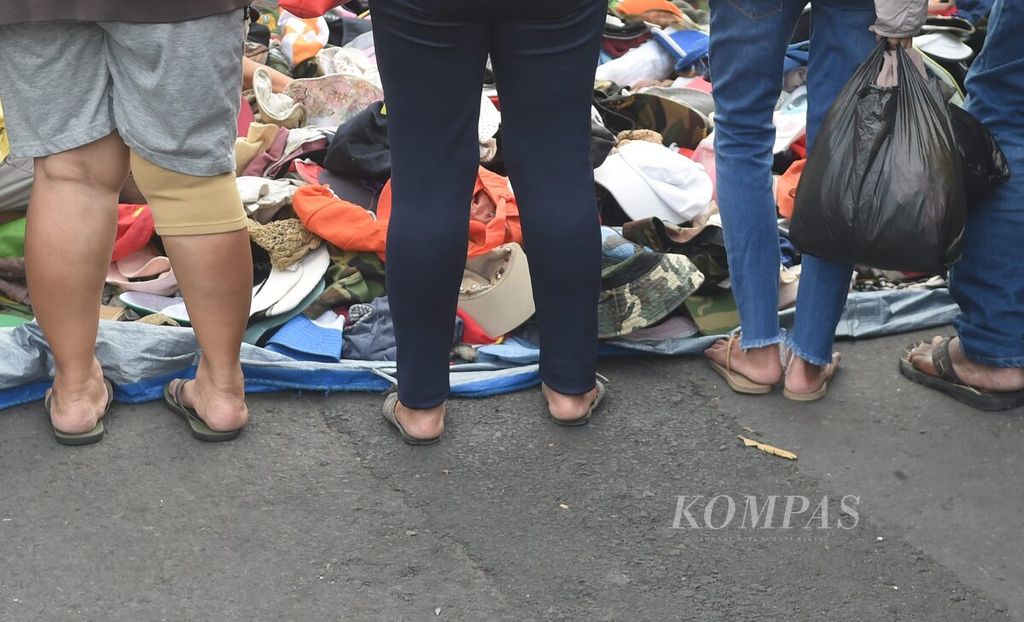 Warga memilih topi bekas impor di Pasar Pagi Tugu Pahlawan, Kota Surabaya, Jawa Timur, 31 Oktober 2021. 