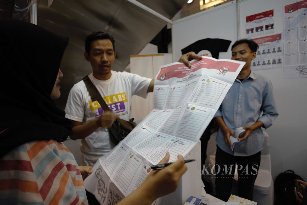 Dengan menggunakan replika surat suara, anggota Perkumpulan untuk Pemilu dan Demokrasi (Perludem) menjelaskan tata cara mencoblos kepada pengunjung di Gedung Sarinah, Jakarta, Minggu (24/12/2023).  