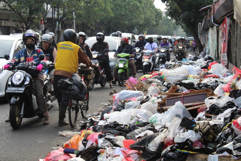 Seorang pengendara sepeda melewati tumpukan sampah di ruas Jalan Ahmad Yani dekat Pasar Cicadas, Kota Bandung, Jawa Barat, Selasa (7/11/2023). 