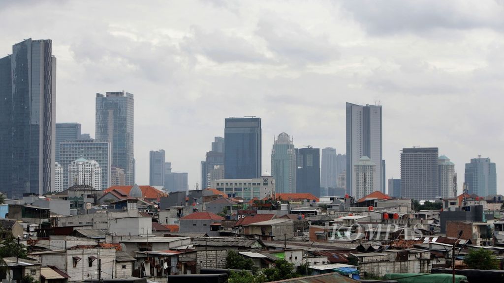 Perkampungan padat penduduk dengan latar belakang gedung bertingkat di Jakarta, Jumat (23/12/2022). Pemerintah akan melanjutkan program perlindungan sosial untuk mendorong tingkat kemiskinan pada 2023 menurun di kisaran 7,5-8,5 persen, tingkat pengangguran terbuka berkisar  5,3-6,0 persen, dan perbaikan ketimpangan (rasio gini) menjadi 0,375-0,378. 