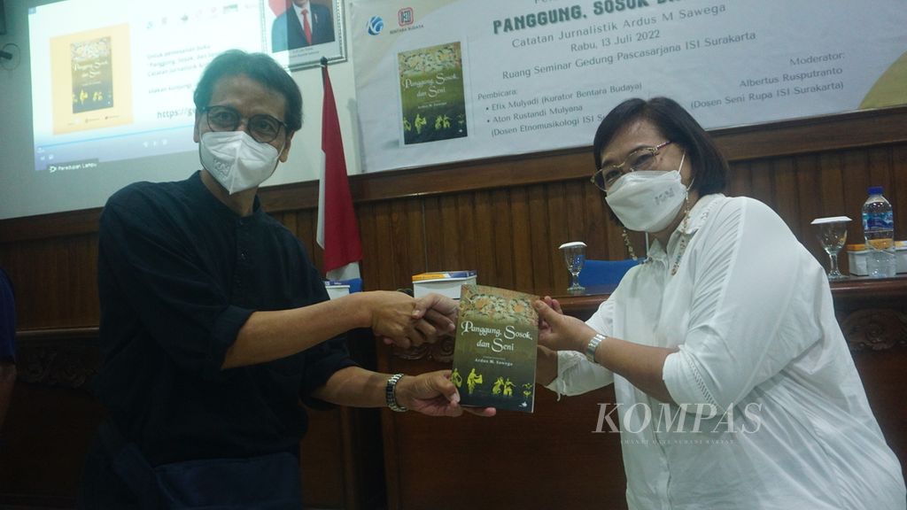 Kurator Bentara Budaya Frans Sartono (kiri) memberikan buku berjudul <i>Panggung, Seni, dan Sosok: Catatan Jurnalistik Ardus M Sawega</i> kepada istri Ardus, Retno Susilaningsih (kanan), yang diluncurkan, di Institut Seni Indonesia Surakarta, Kota Surakarta, Jawa Tengah, Rabu (13/7/2022). Buku itu berisi tulisan wartawan senior harian <i>Kompas</i> Ardus M Sawega mengenai peristiwa kesenian dan budaya selama masih aktif menjadi wartawan.