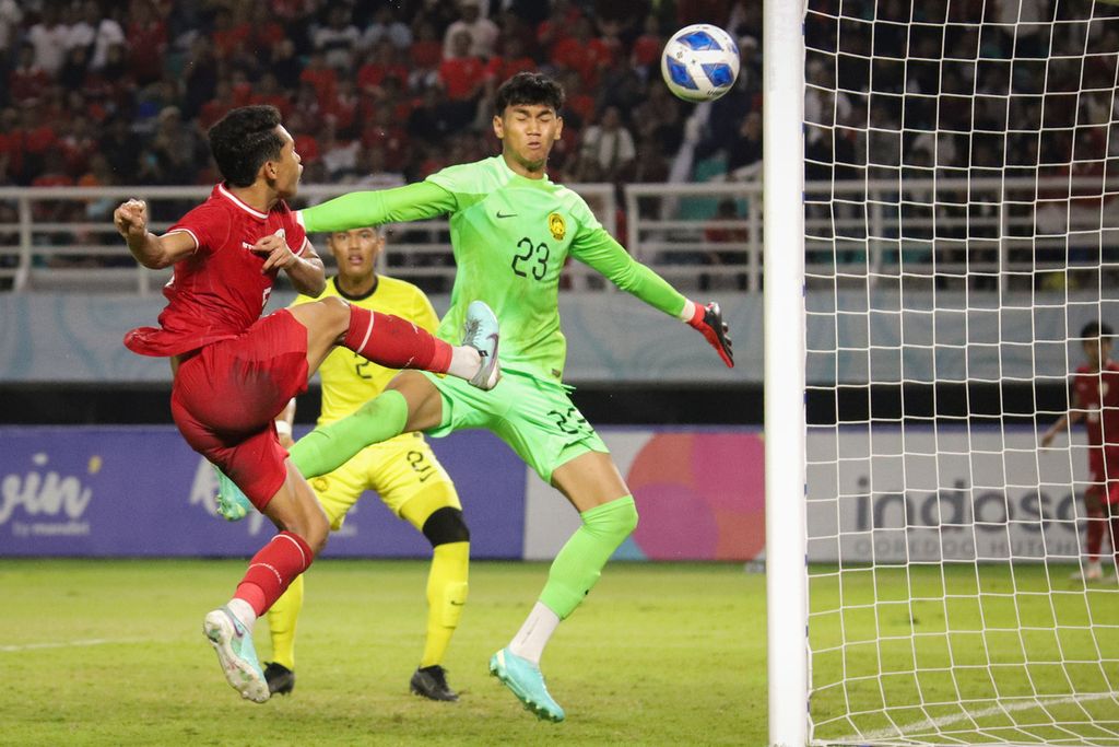 Pemain Indonesia, Muhammad Alfharezzi Buffon (kiri), berusaha menjebol gawang Malaysia pada pertandingan semifinal Piala AFF U-19 di Stadion Gelora Bung Tomo, Surabaya, Jawa Timur, Sabtu (27/7/2024). Indonesia lolos ke final seusai menang dengan skor 1-0.