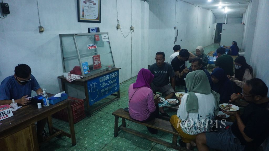 Para pelanggan tengah menyantap makanan yang dipesannya di Gudeg Ceker Bu Kasno, Kota Surakarta, Jawa Tengah, Sabtu (9/4/2022). Warung tersebut baru beroperasi lepas tengah malam. Untuk itu, banyak warga yang menjadikannya andalan sebagai tempat mencari santap sahur di masa Ramadhan ini. Menu andalannya ialah gudeg ceker.