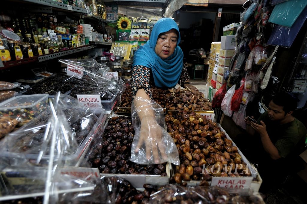 Pedagang merapikan kurma dagangannya di Pasar Jatinegara, Jakarta, Jumat (8/3/2024).