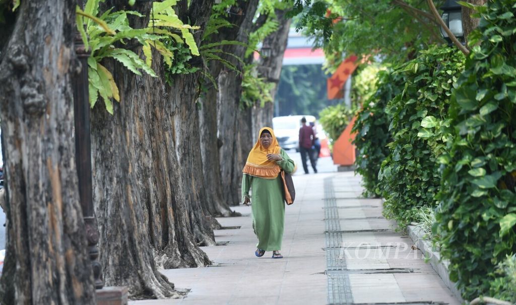 Warga berjalan di jalur pedestrian yang luas, bersih dan hijau, Kota Surabaya, Jawa Timur, November 2019. Hingga 2024, Surabaya telah menerima penghargaan Piala Adipura Kencana delapan kali berturut-turut. 