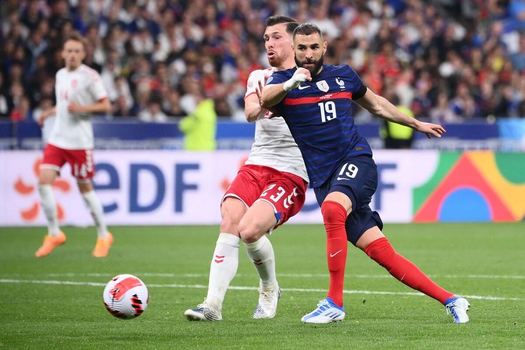 Penyerang Perancis, Karim Benzema (kanan), berupaya mempertahankan bola saat dikawal pemain Denmark, Pierre-Emile Hojbjerg, pada laga penyisihan grup Liga Nasional Eropa di Stadion Stade de France, Perancis, in Saint-Denis, Jumat (3/6/2022) waktu setempat. Perancis takluk, 1-2, pada laga itu. 