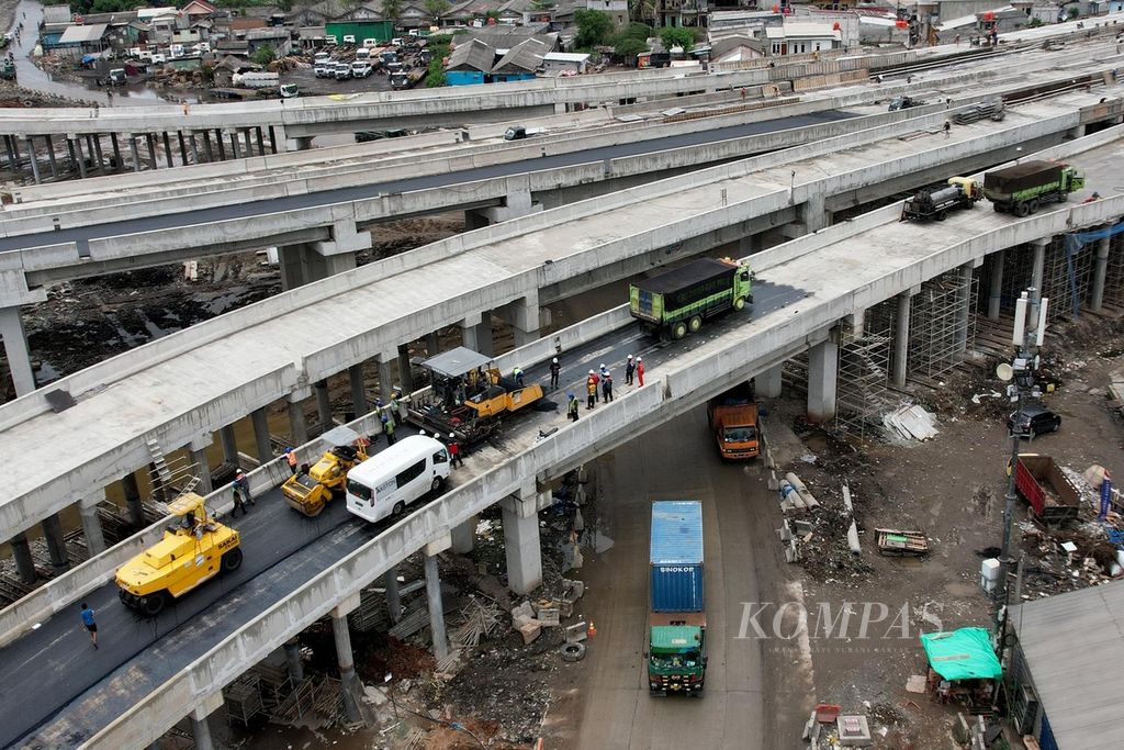 Pekerja mengaspal jalan layang susun yang menghubungkan Jalan Tol Cibitung-Cilincing (JTCC) Seksi 4, Tarumajaya-Cilincing, dengan Jakarta Outer Ring Road dan jalan arteri Cilincing, Jakarta, Rabu (22/2/2023). 