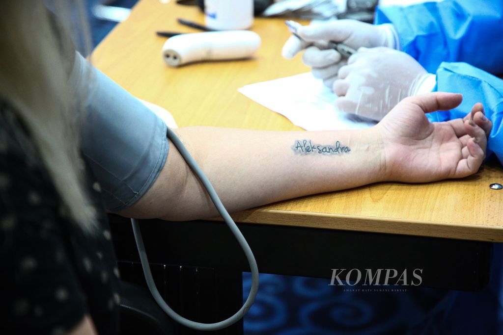 Seorang warga negara asing asal Rusia menjalanni pemeriksaan tekanan darah sebelum menerima vaksin Covid-19 Sinopharm di Balai Kota, Jakarta Pusat, Selasa (24/8/2021).