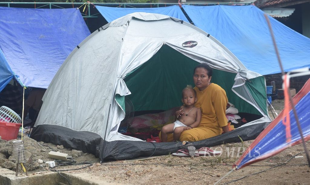 Warga berada di tenda saat tenaga kesehatan Puskesmas Sangkapura memeriksa kesehatan warga di pengungsian korban gempa Desa Suwari, Kecamatan Sangkapura di Pulau Bawean, Gresik, Selasa (26/3/2024). 