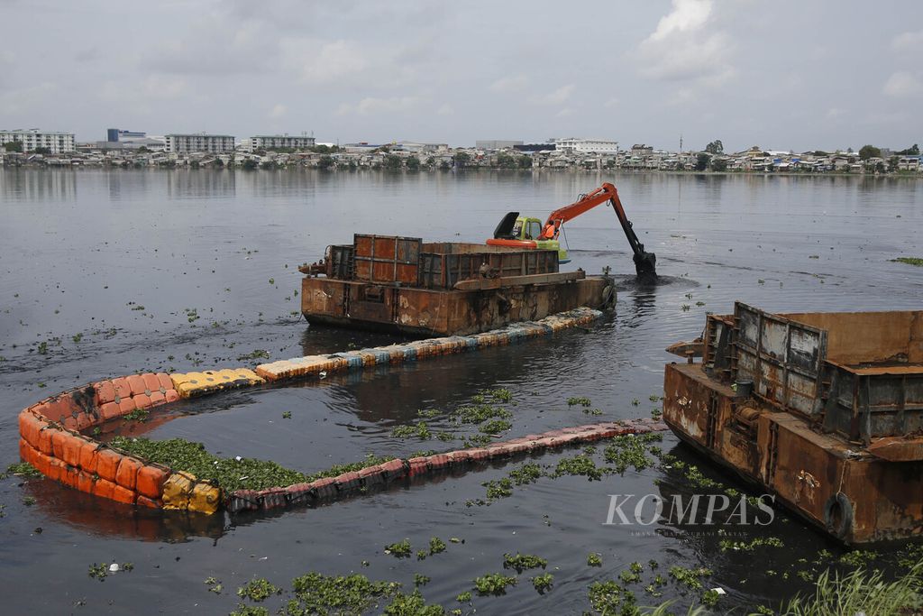 UPK officials from the Environmental Agency of DKI Jakarta used an excavator to dredge mud and catch water hyacinths present in the Pluit Reservoir on Tuesday (30/1/2024).