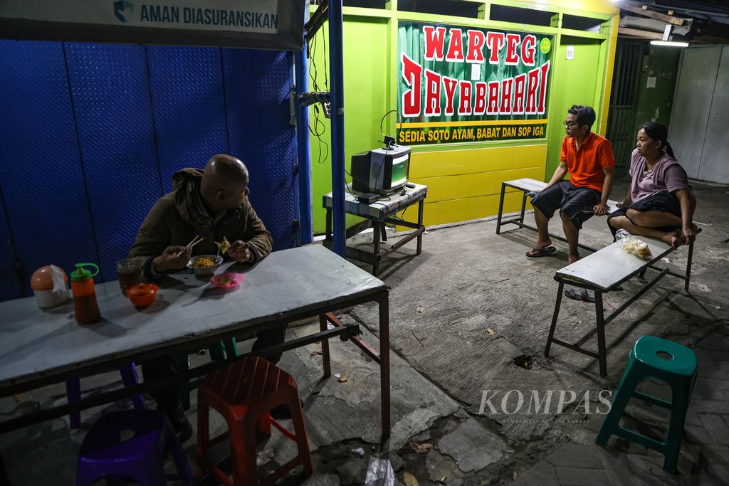 Residents watched the Indonesia vs Iraq match in the U-23 Asia Cup in front of a closed warung (small food stall) on Jalan Palmerah Barat, South Jakarta, Friday (3/5/2024).