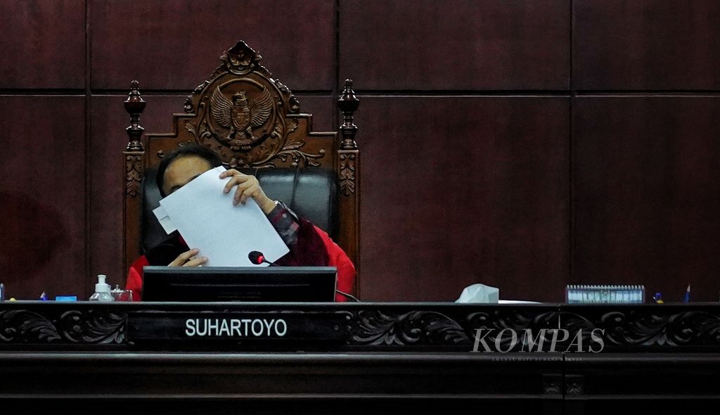 Ketua Mahkamah Konstitusi Suhartoyo mengangkat salah satu berkas yang dibacakan dalam sidang putusan uji formil terhadap Putusan MK Nomor 90/PUU-XXI/2023 di Jakarta, Selasa (16/1/2024).