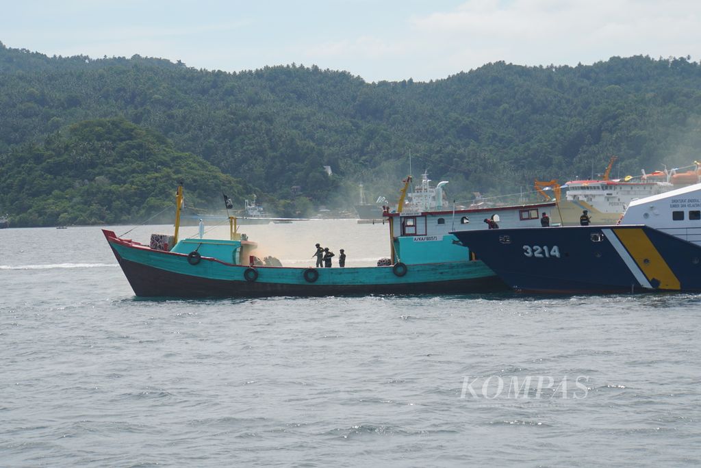 Pasukan Pengawasan Sumber Daya Kelautan dan Perikanan (PSDKP) menampilkan atraksi simulasi penangkapan kapal pelaku praktik perikanan ilegal dalam upacara gelar pasukan di Pelabuhan Samudra Bitung, Sulawesi Utara, Selasa (23/11/2021).