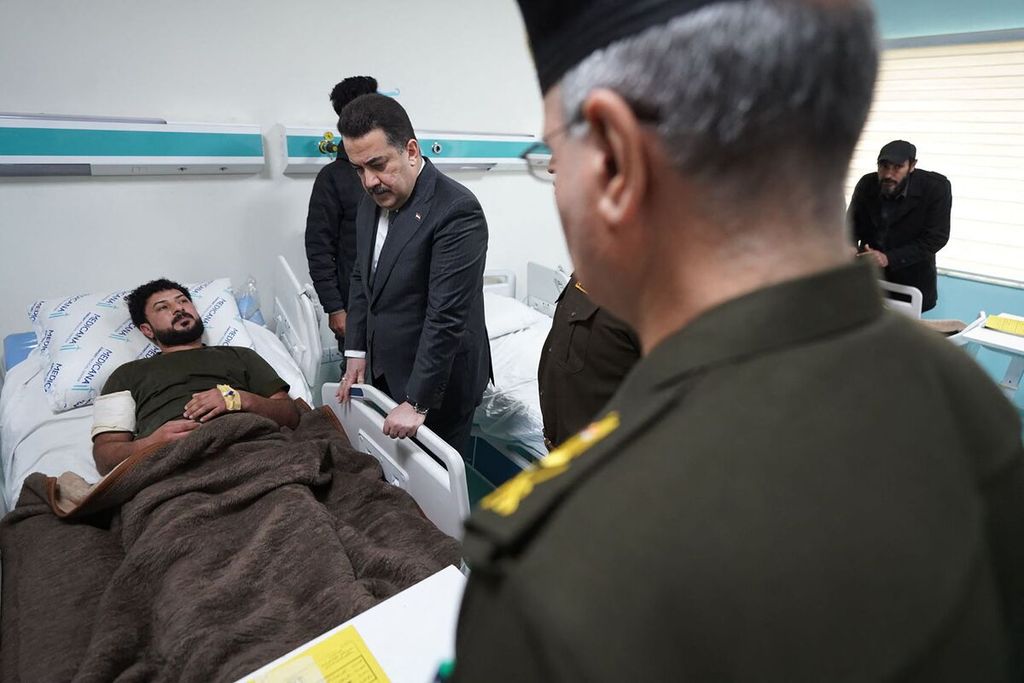 Melalui foto yang dirilis Kantor Media Perdana Menteri Irak, Minggu (4/2/2024), tampak Perdana Menteri Irak Mohamed Shia al-Sudani (tengah) mengunjungi pasien yang dirawat di rumah sakit di Baghdad. 