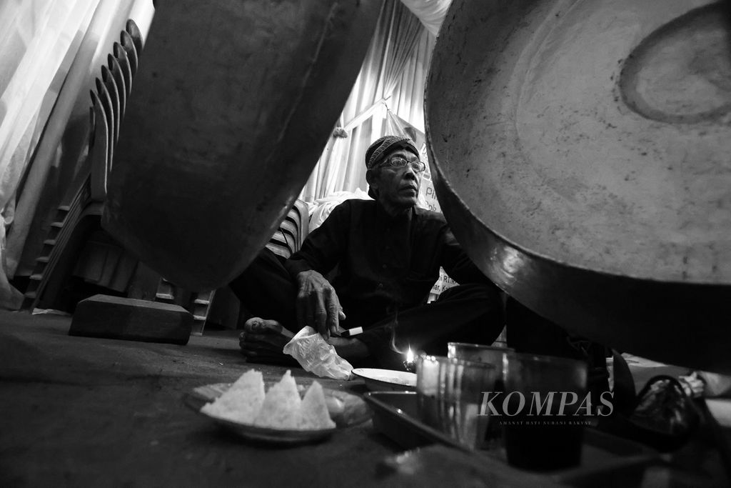 Pawang Kasmudi Karsim (72) berdoa di depan perangkat gamelan dan sesaji sebelum dimulainya pertunjukan seni Sintren.