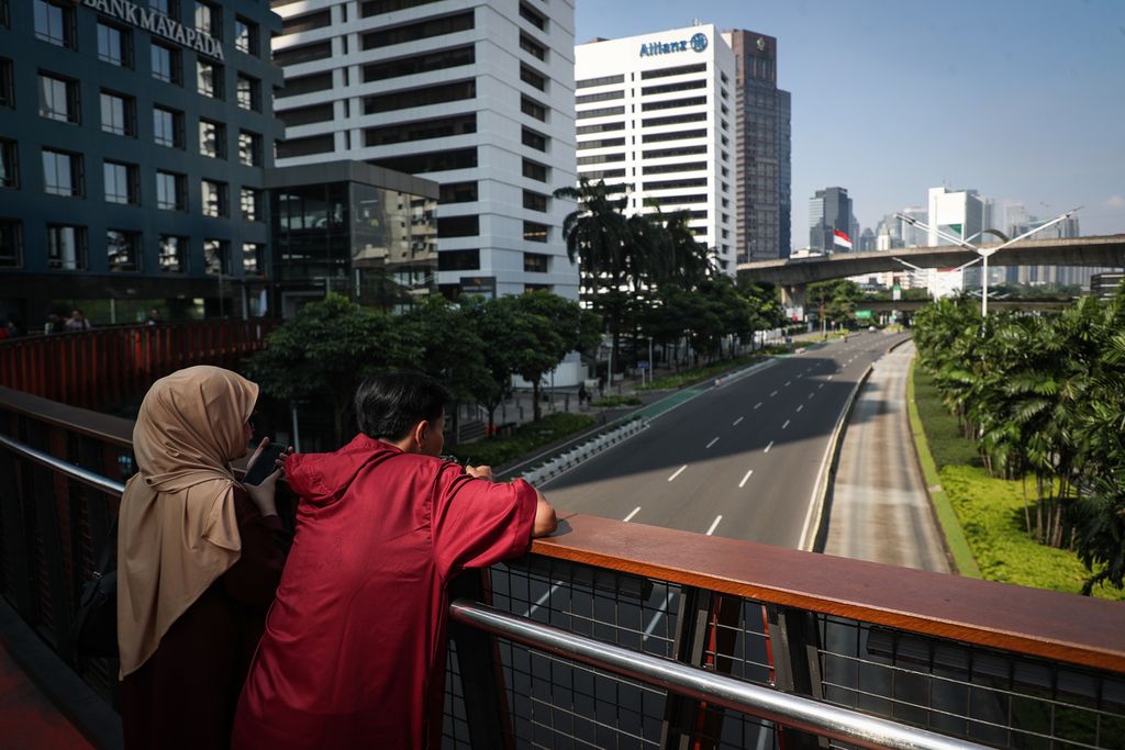 Warga menikmati suasana lengang dari Jembatan Phinisi, Jakarta Pusat, Minggu (23/4/2023). 