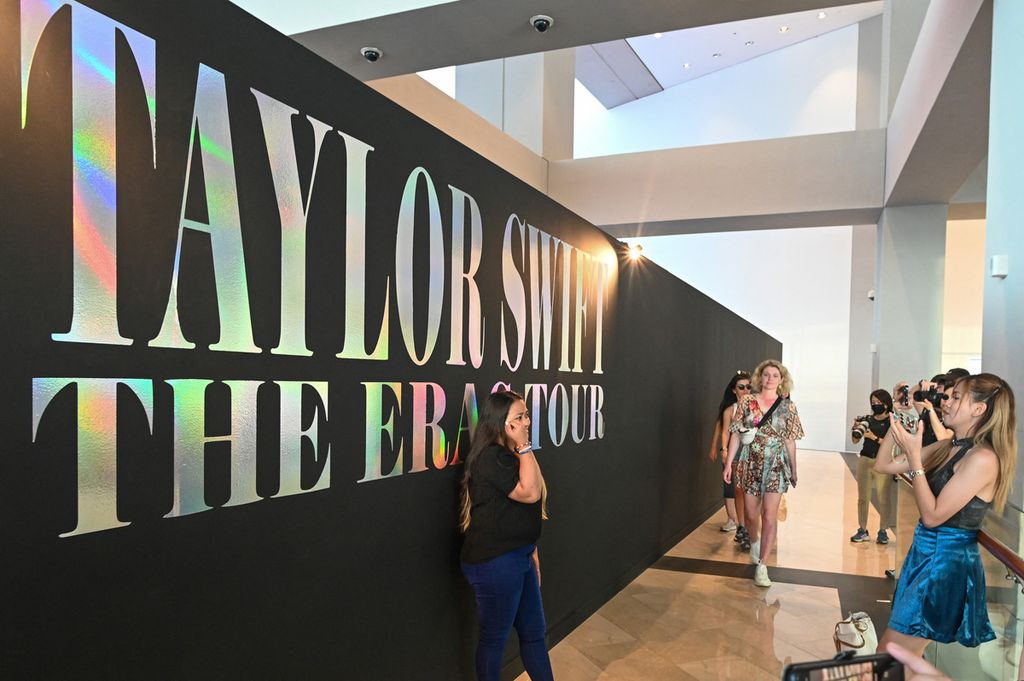 Penggemar Taylor Swift alias Swifties berfoto ria pada papan penanda Eras Tour Trail di kompleks Marina Bay Sands, Singapura, Rabu (28/2/2024). Sekurangnya 300,000 Swifties dari Singapura dan negeri tetangga akan memenuhi National Stadium, tempat konser bertajuk The Eras Tour<i>.</i>