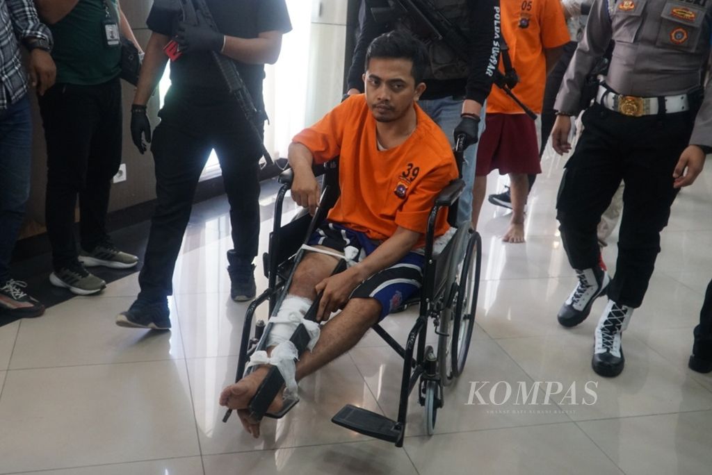 IS (34), tersangka perampokan emas, didorong ke ruang tahanan menggunakan kursi roda dalam konferensi pers di Polda Sumatera Barat, Kota Padang, Selasa (30/1/2024). 