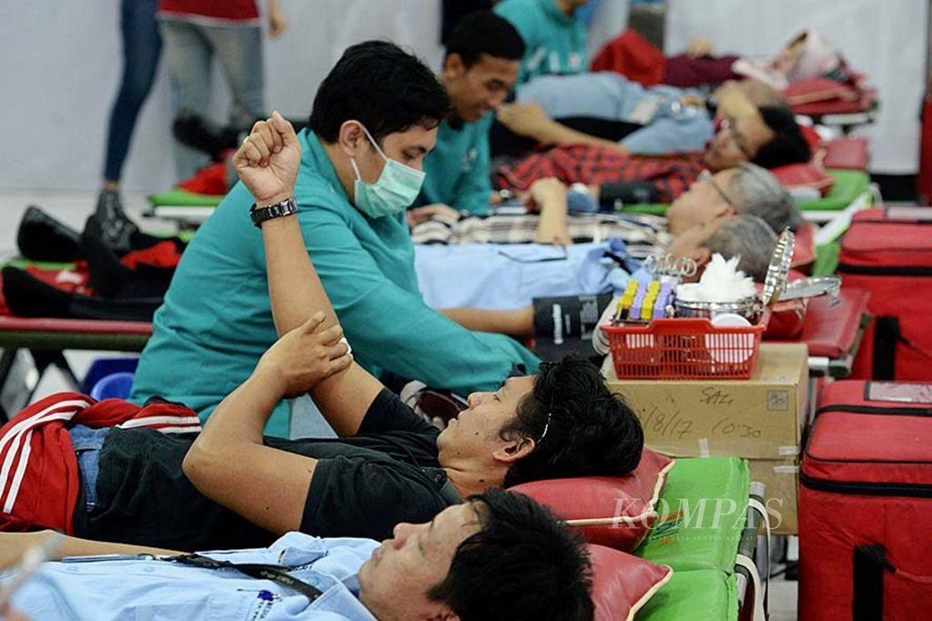 Para karyawan Kompas Gramedia mengikuti kegiatan donor darah massal di area perkantoran Kompas Gramedia Palmerah Selatan, Jakarta, Kamis (31/8/2017). Selain bisa membantu menyelamatkan hidup orang lain, kegiatan tersebut juga memiliki banyak manfaat bagi donor, seperti menjaga kesehatan jantung dan menurunkan risiko kanker.