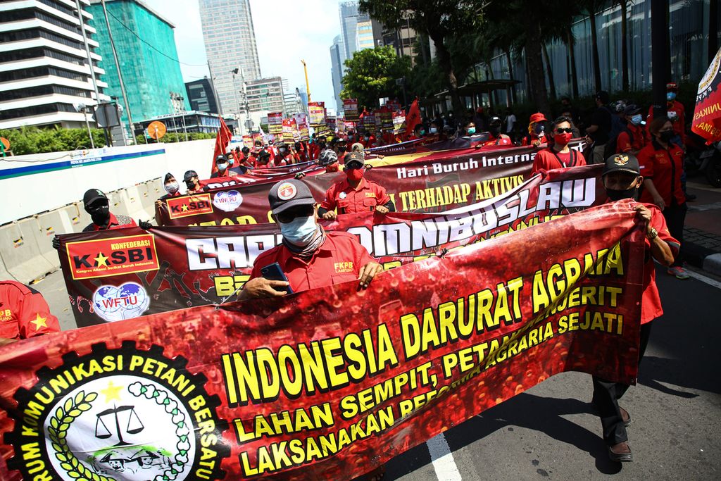 Massa buruh yang tergabung dalam Kongres Aliansi Serikat Buruh Indonesia (Kasbi) berunjuk rasa memperingati Hari Buruh Internasional di Jakarta, Sabtu (1/5/2021). Peringatan Hari Buruh oleh massa buruh dan mahasiswa ini menyuarakan pencabutan terhadap Undang-Undang Cipta Kerja. 