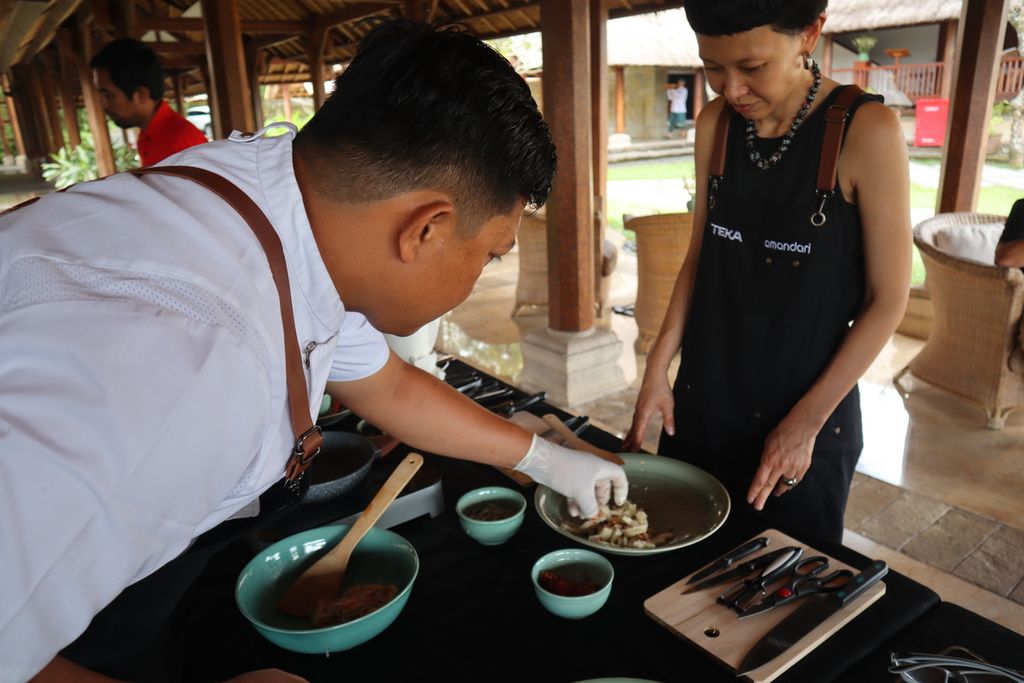 <i>Chef </i>I Wayan Kresna Yasa mencontohkan ukuran potongan timun kepada seorang peserta kelas memasak, di resor Amandari, Kedewatan, Ubud, Bali, Sabtu (20/5/2023) siang.