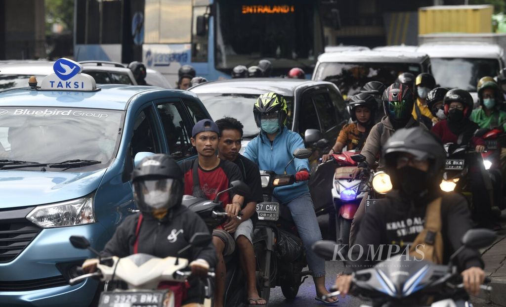  Motorcycle riders do not wear masks while on the West Outer Ring Road, West Jakarta, Monday (7/3/2022).