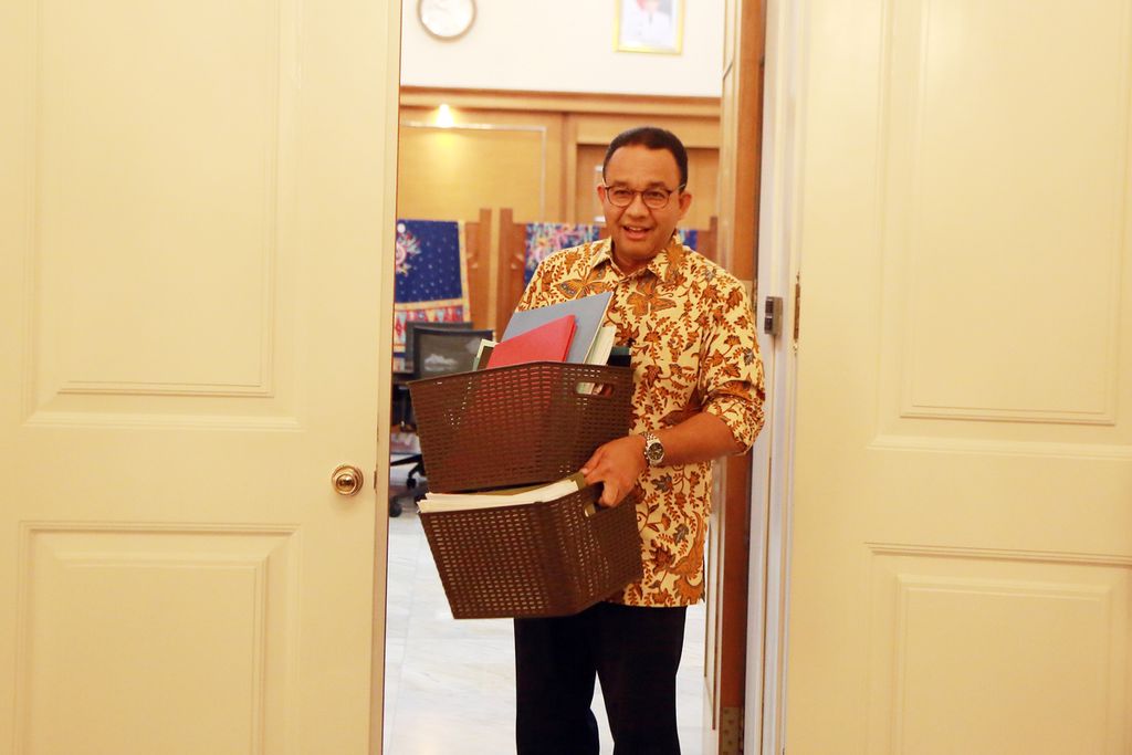 Gubernur DKI Jakarta Anies Baswedan berjalan keluar ruang kerjanya membawa berkas miliknya menjelang purna tugas menjadi gubernur di Balai Kota, Jakarta, Jumat (14/10/2022). Sejak awal bulan Oktober, ia sudah mulai membereskan barang-barang pribadi yang ada di ruang kantornya. 