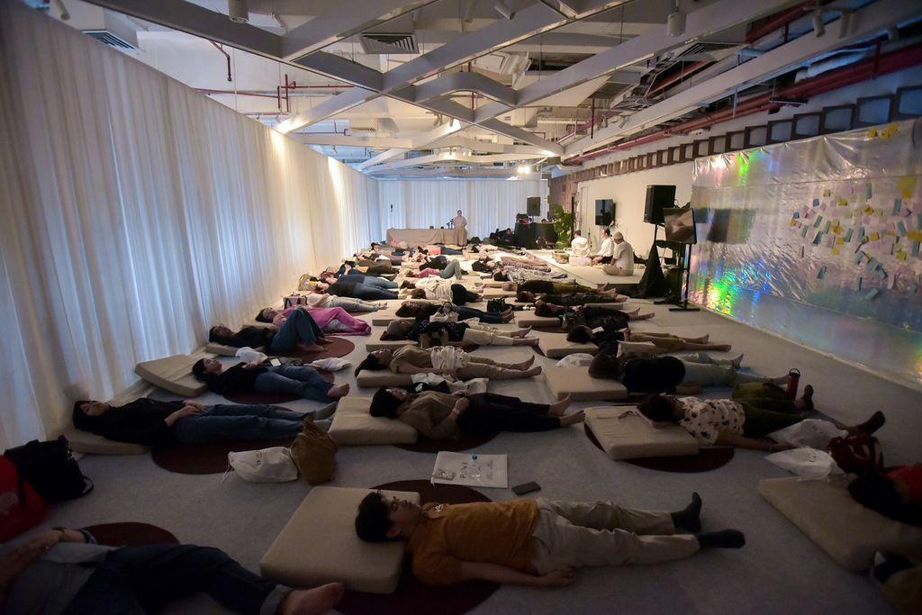 Semua peserta kelas &quot;Sound Journey for Emitional Release&quot; oleh Deece Dewayani dan D.A.Y.A mendengarkan musik yang dimainkan dua couch tersebut, sambil tiduran dalam Plaza Indonesia Wellness Festival, pada Minggu (28/7/2024).