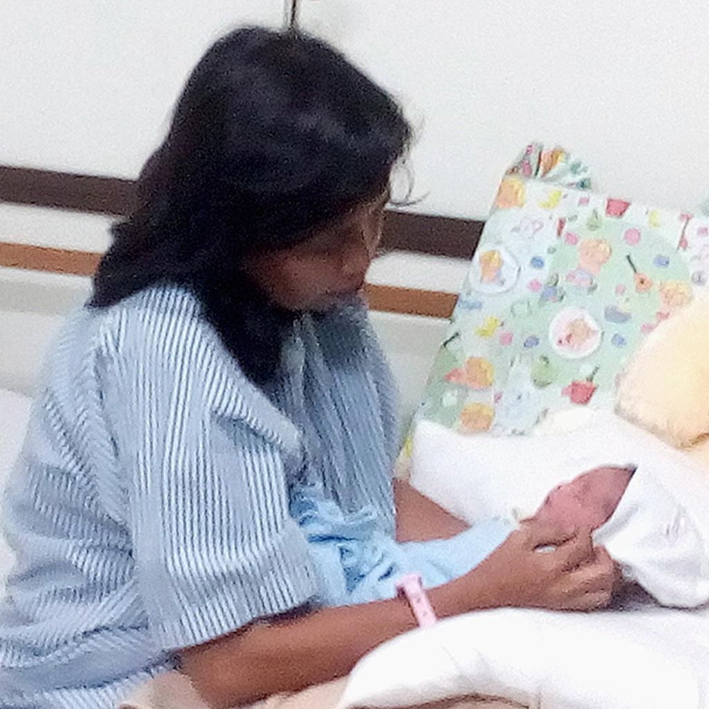 Sugiyati sedang menimang bayi perempuannya yang bernama Bhayangkari Ramadniya di Rumah Sakit Siloam, Purwakarta, Minggu (2/7). Sugiyati melahirkan Bhayangkari di tepi Jalan Tol Cipali dengan pertolongan penumpang bus dan polisi.
