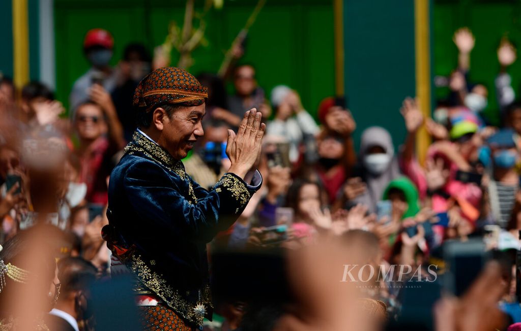 Presiden Joko Widodo menyapa warga yang antusias untuk turut hadir saat pawai pernikahan Kaesang Pangarep-Erina Gudono di Kota Surakarta, Jawa Tengah, Minggu (11/12/2022). 