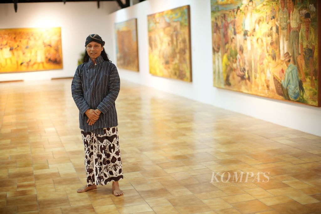 Seniman Budi Ubrux di depan karya-karyanya dalam pameran Ratu Adil karya Budi Ubrux di Bentara Budaya Jakarta.
