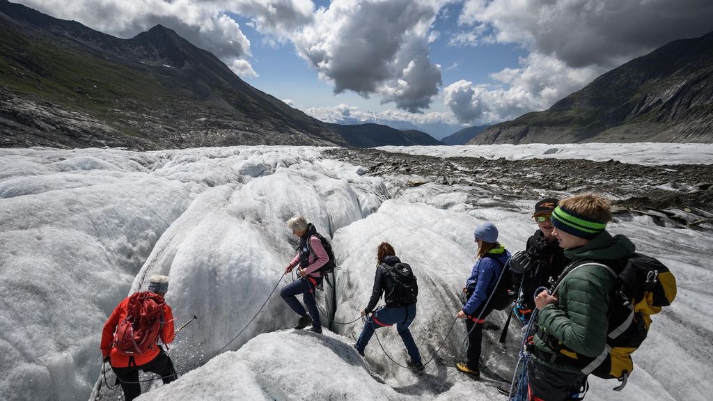Remaja berjalan di atas gletser Aletsch saat menemani ahli glasiologi Swiss, Matthias Huss, melakukan pengukuran terhadap ketinggian gletser terluas di Swiss tersebut. Menurut Huss, gletser seperti termometer raksasa yang menunjukkan kenaikan suhu melalui mencairnya es dan menyusutnya volume. 