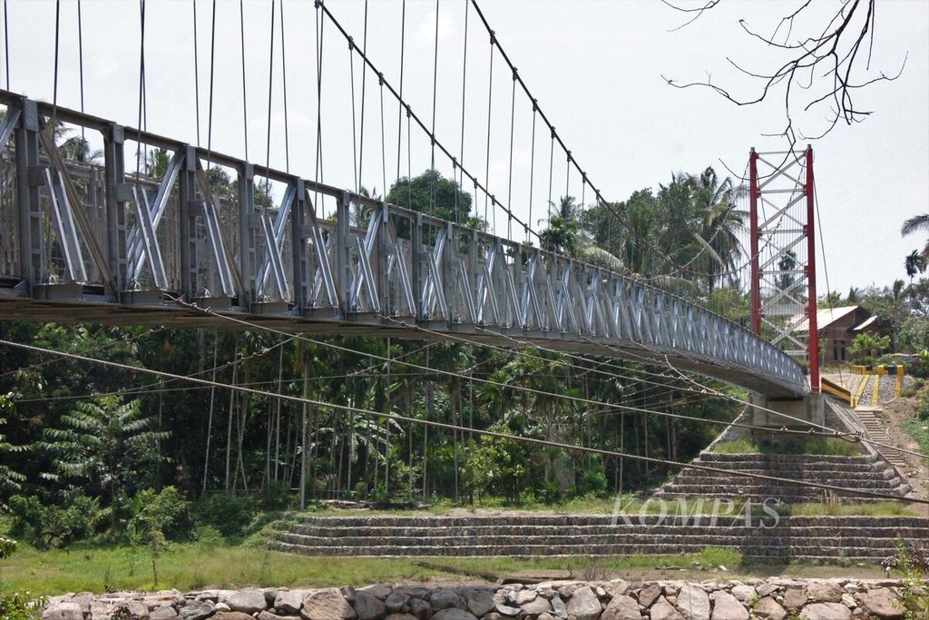 Siswa melaintasi jembatan gantung di Desa Siron, Kecamatan Cot Glie, Kabupaten Aceh Besar, Provinsi Aceh, Kamis (16/3/2023). Setelah sempat terisolasi karena jembatan lama ambruk diterjang banjir, kini kehadiran jembatan tersebut seperti impian warga yang terwujud. 