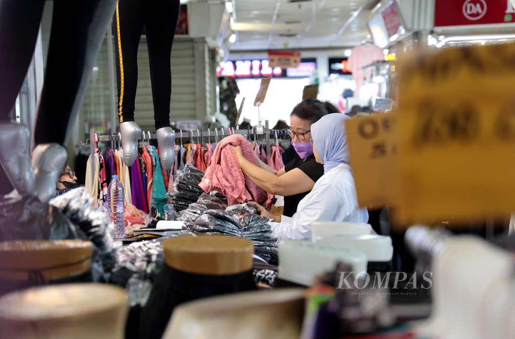 Pengunjung memilih pakaian yang dijual pedagang di Pasar Tanah Abang, Jakarta, Kamis (4/5/2023). Aktivitas perdagangan di salah satu pusat tekstil terbesar di Indonesia ini kembali bergeliat setelah sempat terhenti saat libur Lebaran. 