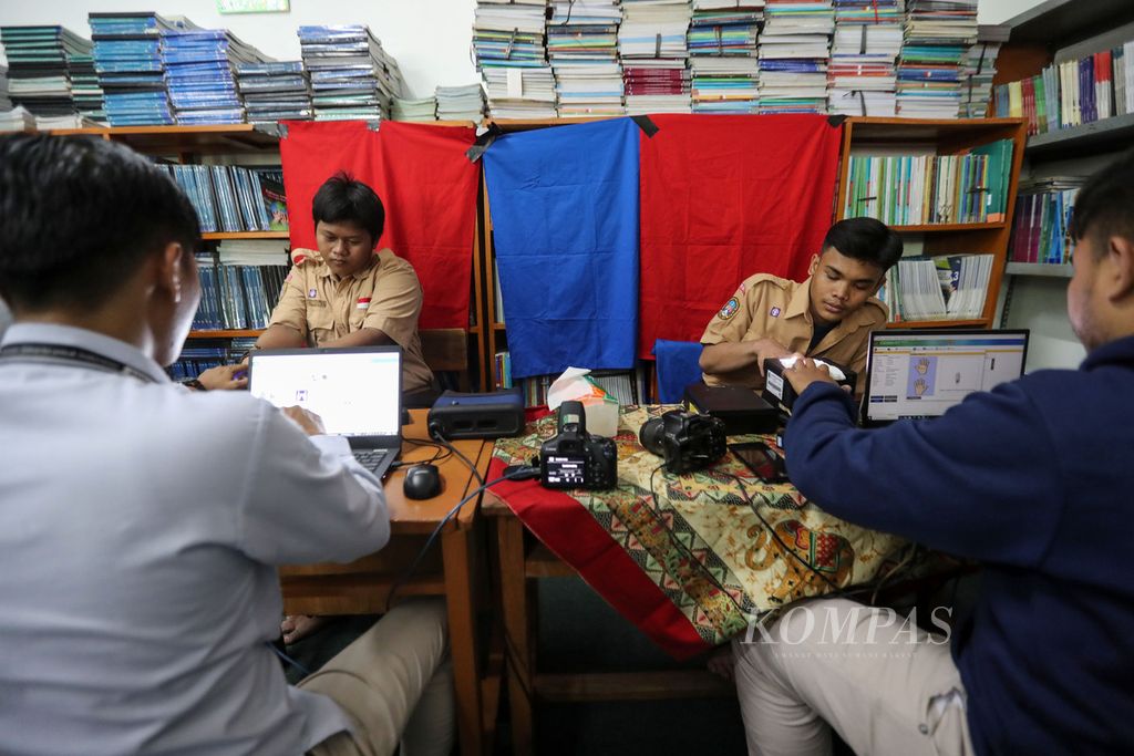 Petugas dinas kependudukan dan catatan sipil meng-<i>input</i> data siswa yang mengikuti perekaman kartu tanda penduduk (KTP) elektronik di SMK Al-Hamidiyah, Jakarta Barat, Rabu (13/9/2023). 
