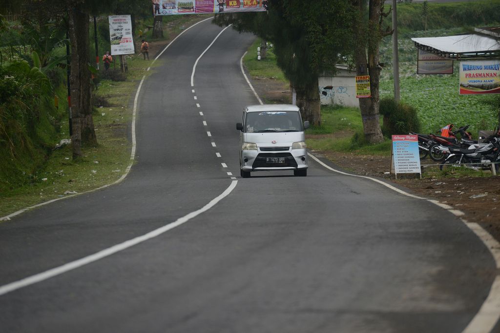 Sebuah mobil berpelat nomor area DKI Jakarta melintas di Jalan Raya Magelang-Kopeng di Kecamatan Pakis, Magelang, Jawa Tengah, awal Mei 2021.