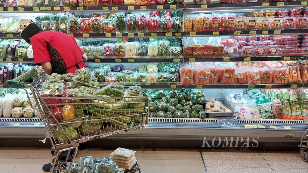 Pekerja menata sayur di salah satu supermarket di Jakarta, Kamis (24/3/2022). Rencana pemerintah untuk menerapkan tarif baru Pajak Pertambahan Nilai (PPN) diperkirakan akan berimbas pada kenaikan harga barang dan jasa konsumsi.