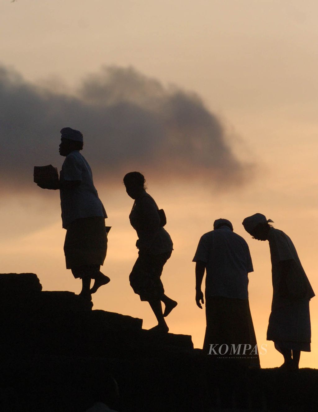 Sejumlah penganut agama Hindu sedang menaiki tangga menuju pura untuk bersembahyang di Tanah Lot, Bali, Minggu beberapa waktu lalu.