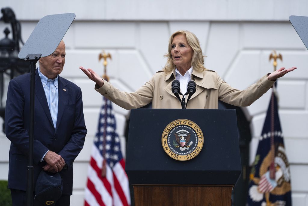 Presiden AS Joe Biden mendengarkan saksama saat Ibu Negara Jill Biden berpidato pada acara barbeku dengan para anggota militer aktif dan keluarga mereka di Halaman Selatan Gedung Putih di Washington DC, AS, 4 Juli 2024. 