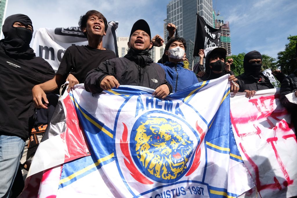 Massa aksi membawa bendera Arema FC di Kawasan Bundaran Hotel Indonesia, Jakarta, Minggu (30/10/2022).
