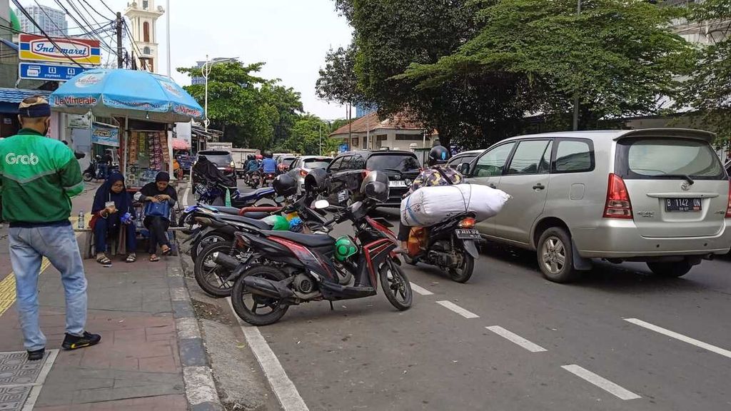 Kondisi jalur sepeda di depan Stasiun Palmerah, Jakarta, Kamis (13/10/2022), yang dipenuhi parkir sepeda motor dan pedagang. Hal ini membuat jalan menyempit dan pengendara sepeda tidak bisa melintas.