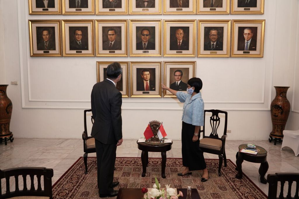 Menteri Luar Negeri Retno LP Marsudi (kanan) memperlihatkan foto-foto menlu Indonesia kepada Menlu China Wang Yi dalam kunjungan Wang di kantor Kementerian Luar Negeri RI, Jakarta, 13 Januari 2021. 