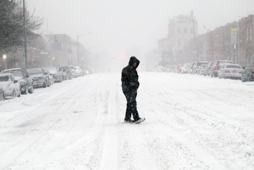 Warga berjalan melintasi jalan yang tertutup salju di Brooklyn, New York City, Amerika Serikat, 29 Januari 2022. 