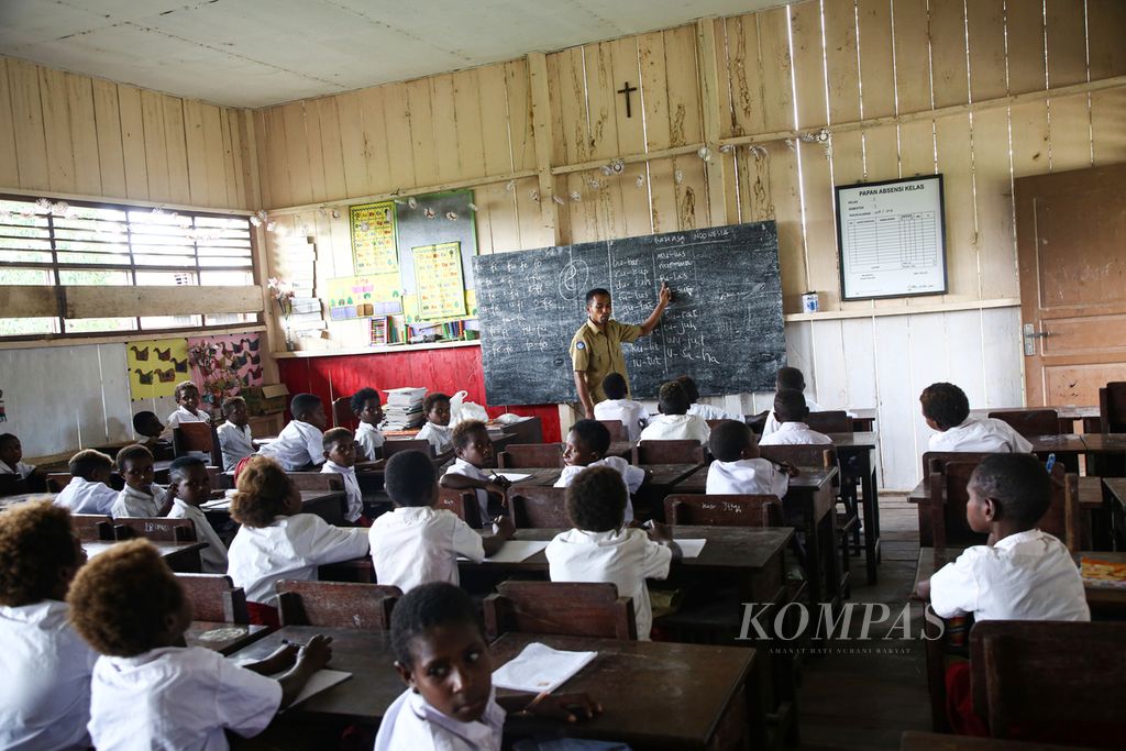 Yansen mengajar siswa kelas I SD YPPK St Agustinus di Manasari, Distrik Mimika Timur Jauh, Kabupaten Mimika, Papua, Senin (4/3/2019). 