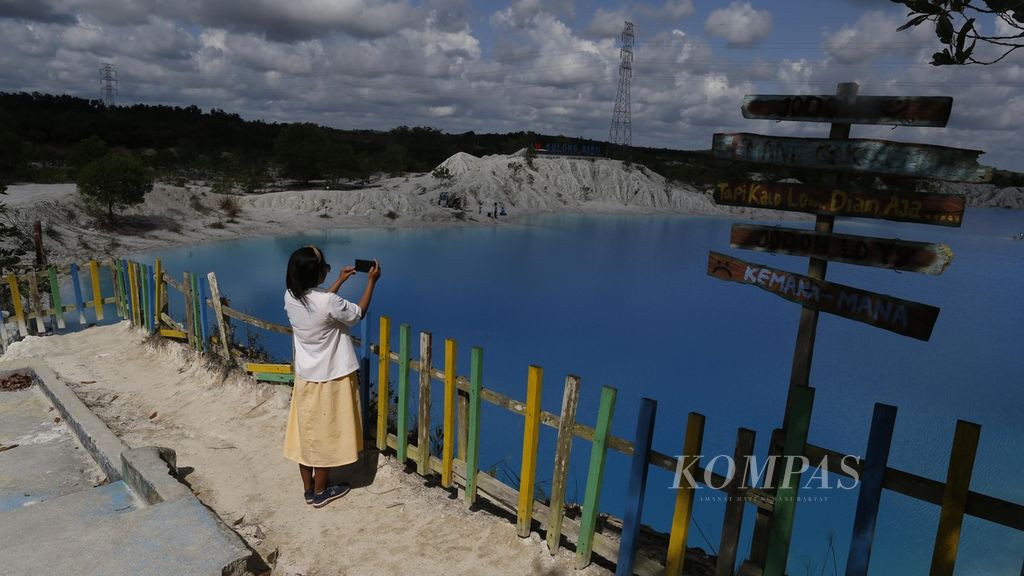 Wisatawan menikmati indahnya lanskap Danau Kaolin di Desa Nibung, Koba, Kabupaten Bangkea Tengah, Bangka Belitung, yang dikelola oleh BUMDes sebagai tempat wisata, Selasa (19/7/2022). BUMDes Nibung mengelola tempat itu sejak tahun 2016 setelah tidak ditambang lagi oleh perusahaan tambang timah swasta. Pendapatan rata-rata BUMDes Nibung dalam mengelola tempat wisata itu adalah Rp 20 juta sebulan. 