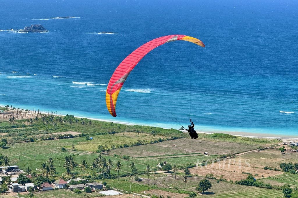 The landscape of Lancing Beach is a treat that tourists enjoy when trying to fly tandem during the International Paragliding Accuracy Championship (IPAC) 1st series 2024 at Sky Lancing Lombok, Mekarsari Village, West Praya District, Central Lombok, West Nusa Tenggara, Saturday (11/ 5/2024). The activity, which was organized by the Indonesian Aero Sport Federation (FASI) Paragliding, 10-14 May 2024, apart from improving the quality and achievements, as well as the ranking of Indonesian paragliding pilots both nationally and internationally, also supports the development of sports tourism (<i>sport tourism< /i>) in NTB.