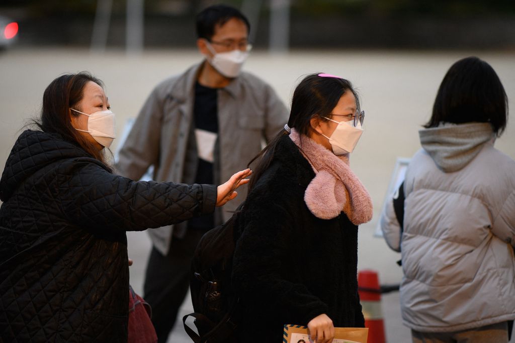 Seorang pelajar (tengah) tiba di tempat ujian <i>suneung</i> yang berlangsung di Seoul, Korea Selatan, Kamis (18/11/2021). Di Korea Selatan, angka kelahiran dilaporkan semakin rendah karena keengganan banyak anak muda di negara tersebut untuk menikah.
