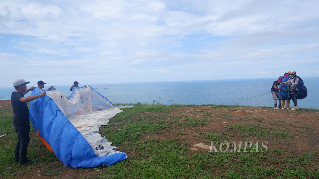 Persiapan terbang tandem paralayang dari puncak Bukit Bapake, Desa Sarang Tiung, Kecamatan Pulau Laut Sigam, Kabupaten Kotabaru, Kalimantan Selatan, Kamis (7/7/2022). 