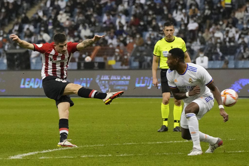 Penyerang Athletic Bilbao, Oihan Sancet (kiri), menendang bola yang berusaha diblok bek Real Madrid, David Alaba, dalam laga Piala Super Spanyol di Stadion King Fahd International, Riyadh, Arab Saudi, Senin (17/1/2022).