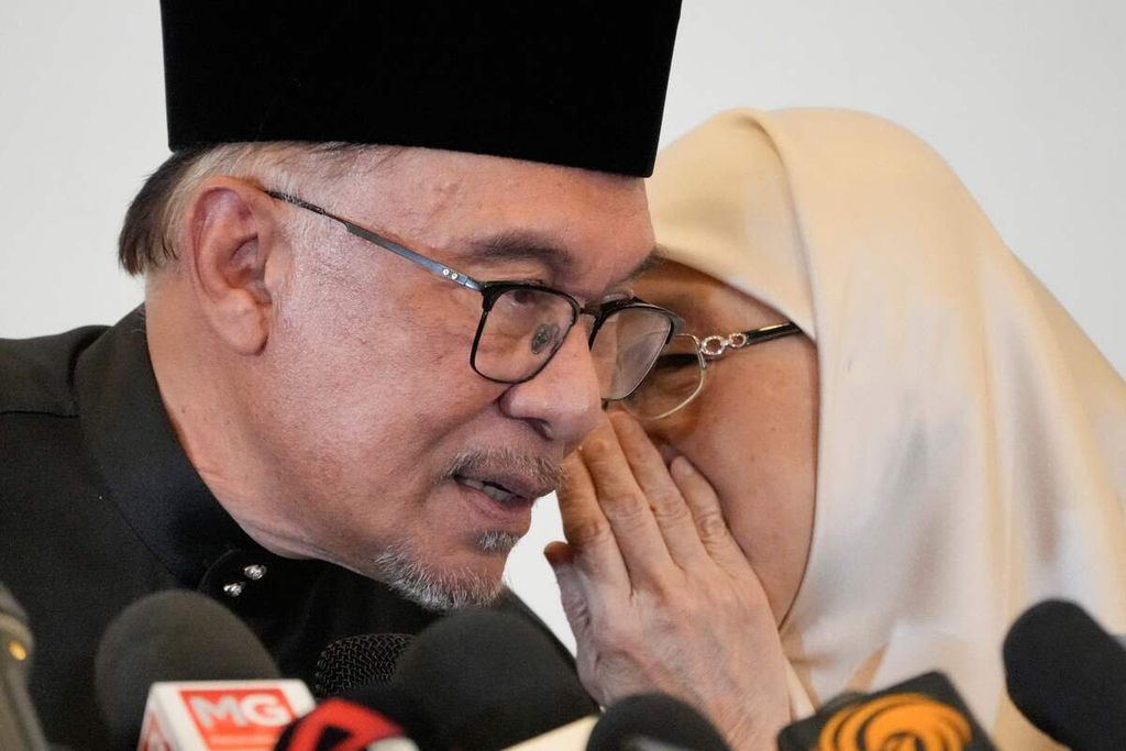 PM baru Malaysia Anwar Ibrahim berbicara dengan istrinya, Wan Azizah, dalam konferensi pers di Kuala Lumpur, Malaysia, Kamis (24/11/2022). 